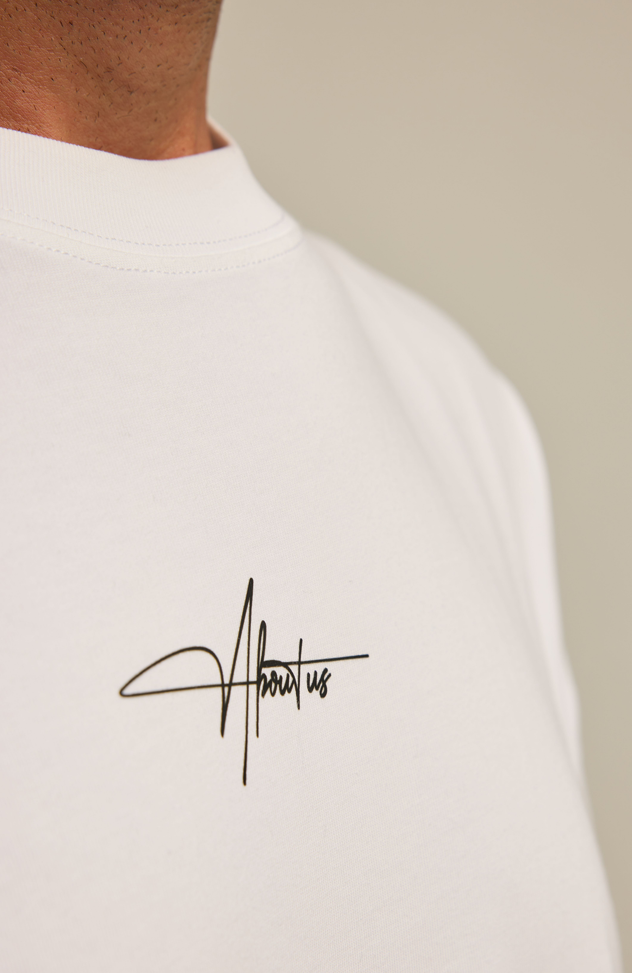 About Us Signature Logo Loose Fit T-Shirt — chest signature logo detail