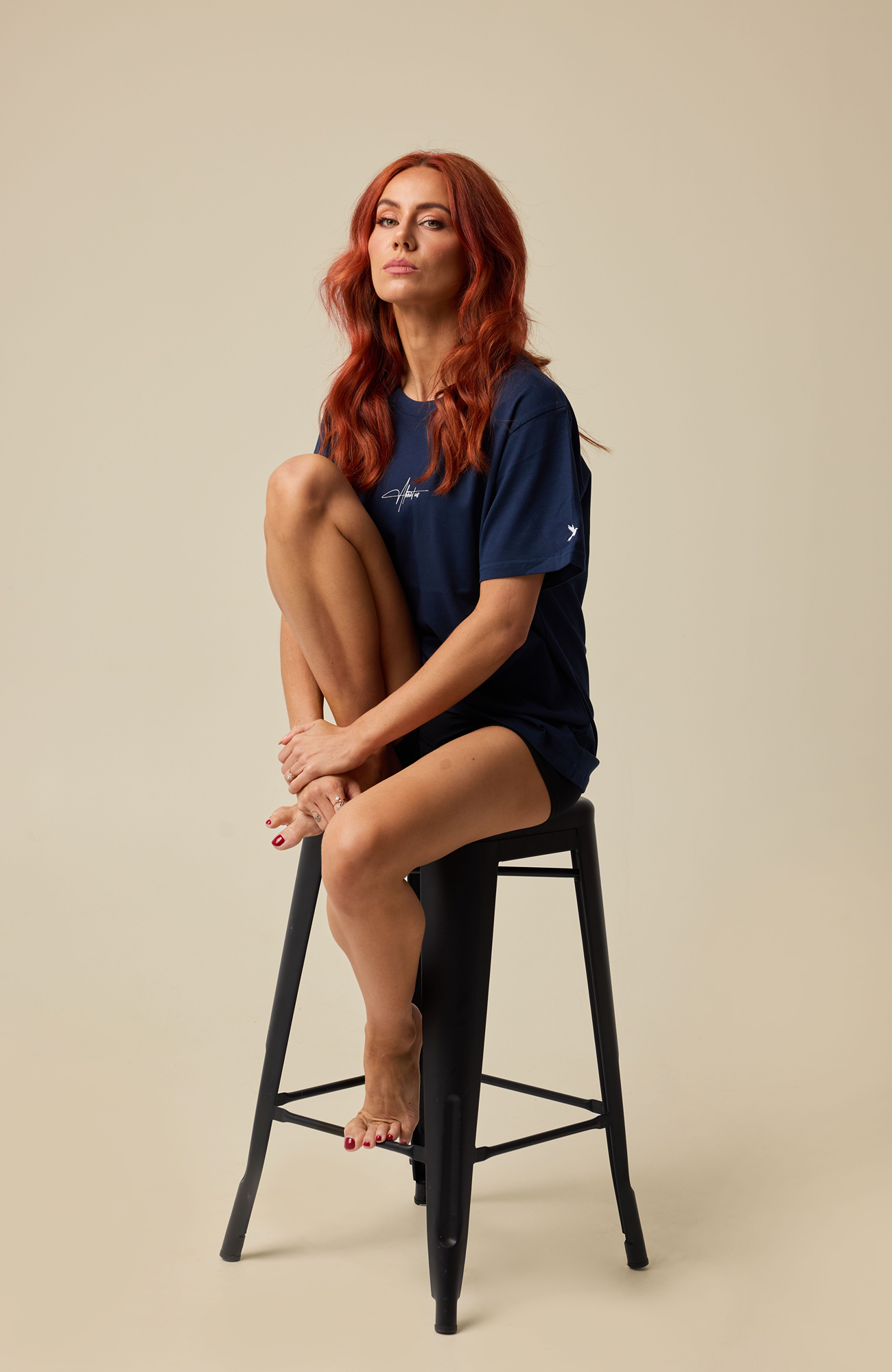About Us Aura navy activewear, seated lifestyle